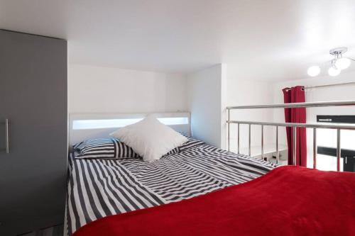 une chambre avec un lit avec une couverture rouge dans l'établissement Ideal for exploring Paris on foot, à Paris