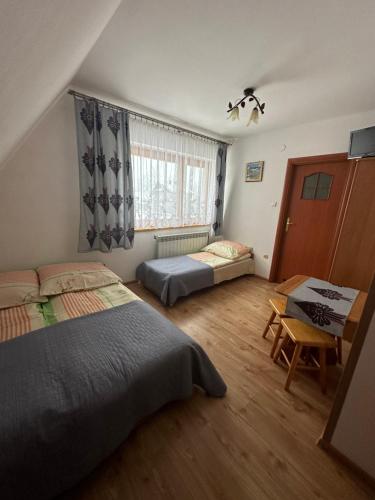 a bedroom with two beds and a table and a desk at Murań in Czarna Góra