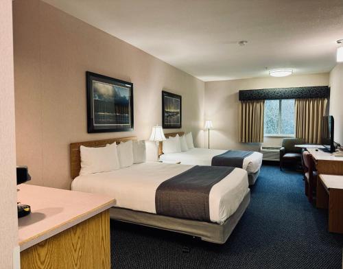 a hotel room with two beds and a desk at The Tillamook Inn in Tillamook