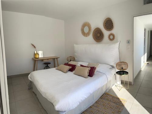 un letto bianco con cuscini sopra di Oasis Blue Perpignan Canet a Perpignano