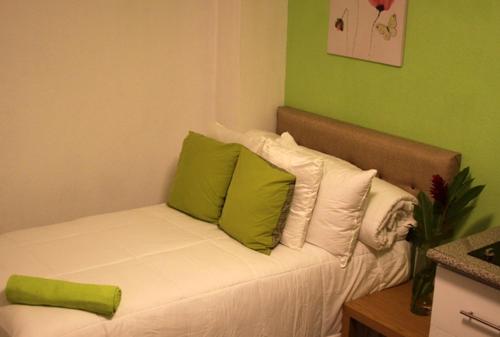 un sofá con almohadas verdes y blancas en una habitación en Super Precio en Guatemala