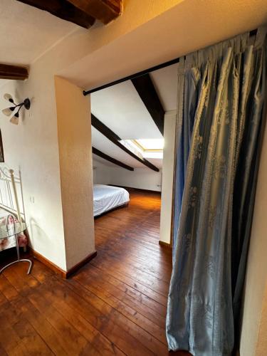an attic room with a bed and a curtain at CASA LORI - Tuscan ToBe in Santa Fiora