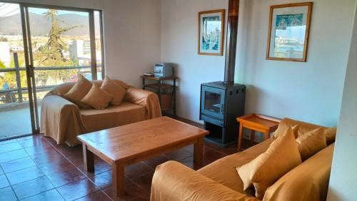 sala de estar con 2 sofás y estufa de leña en casa en la herradura coquimbo, en Coquimbo