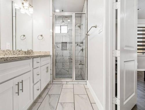 uma casa de banho branca com um chuveiro e um lavatório. em King bed in gated community, 1300 sqft home em Houston