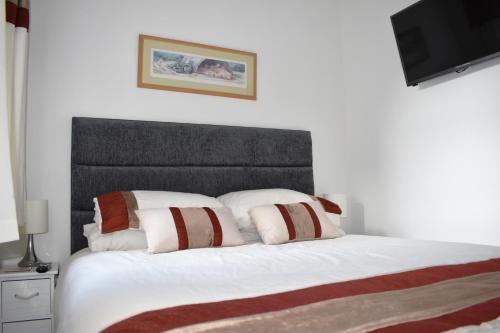a bedroom with a white bed with a black headboard at Harbour Penthouse Whitby in Whitby