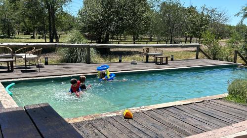 dos niños están jugando en una piscina en Casa de Campo en LA GUAPEADA POLO, Pilar en Pilar