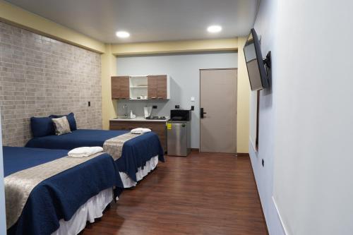 a hotel room with two beds and a television at Villa Las Flores in San Salvador