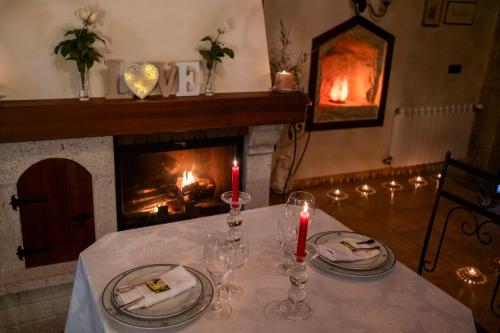 een tafel met twee kaarsen en een open haard bij Casa do Sear - Turismo Rural & Spa Exterior in Sanxenxo