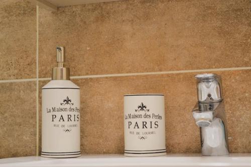 three bottles of parins sitting on top of a sink at Stelios apartment in Kastoria