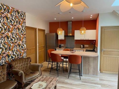 une cuisine avec une table et des chaises dans une pièce dans l'établissement Gîte 5 personnes le bas du bois, à Moitron-sur-Sarthe