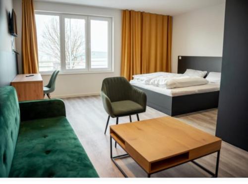 Hotel Central Vis a Vis في ماينز: غرفة نوم بسرير واريكة وطاولة