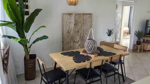 een eettafel met stoelen en een vaas erop bij Charming apartment close to beach & amenities - Appartement de charme proche plage in Flic-en-Flac