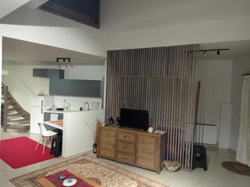 a living room with a television on a wooden cabinet at Ioa Loft in Ioannina