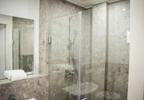 bagno con doccia e porta in vetro di Hotel Central Vis a Vis a Magonza
