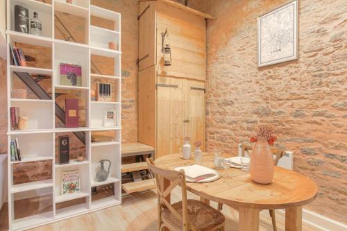 une salle à manger avec une table en bois et des étagères blanches dans l'établissement Duplex de caractère en hypercentre, à Lyon