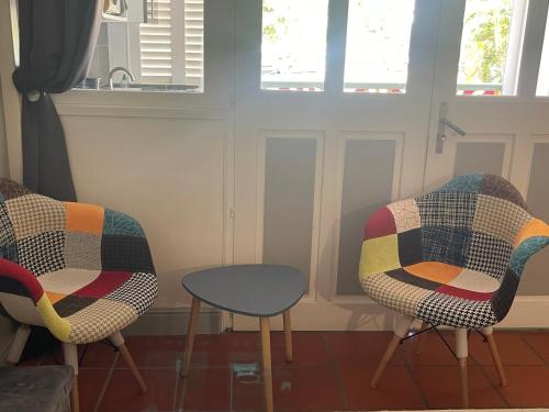 two chairs and a table in a room at FLAMBOYANT St Francois in Saint-François