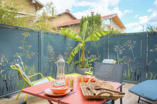 a patio with a red table and chairs at Romantique et Sensuelle in Dardilly