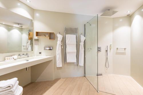 a bathroom with a shower and a sink at Hotel des Lices in Saint-Tropez