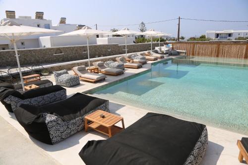 a large swimming pool with lounge chairs and umbrellas at Irene's Residence in Mikonos