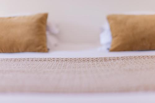 a close up of a bed with two pillows at Hotel des Lices in Saint-Tropez