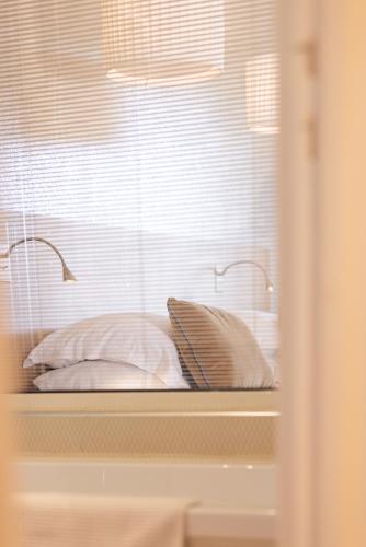 a reflection of a bed in a window at Hotel des Lices in Saint-Tropez