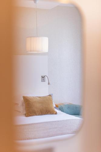 a bedroom with a bed with a pillow and a lamp at Hotel des Lices in Saint-Tropez
