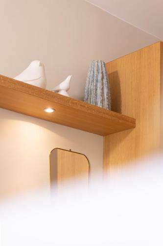 a wooden shelf with vases and a mirror on it at Hotel des Lices in Saint-Tropez