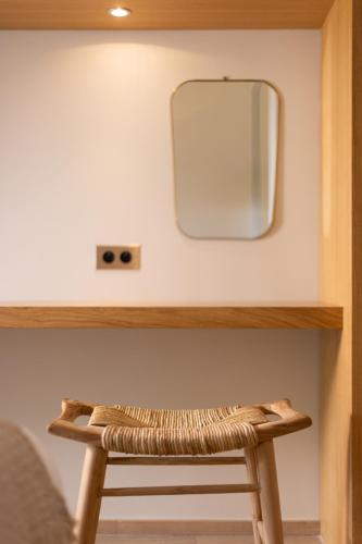 a wooden stool with a mirror on a wall at Hotel des Lices in Saint-Tropez