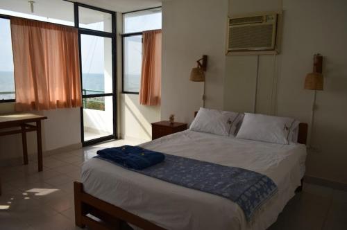 1 dormitorio con 1 cama grande y ventana en Punta Cocos Beach Casitas en Zorritos