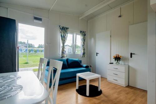 Holiday house for 4 people, pool, sauna, Ustronie في أوستروني مورسكي: غرفة معيشة مع أريكة زرقاء وطاولة