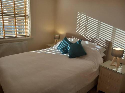 a bedroom with a white bed with two pillows on it at Spacious 2 double bed apartment - Free Parking - Central Beeston location in Nottingham