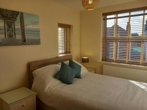 um quarto com uma cama com almofadas verdes e uma janela em Spacious 2 double bed apartment - Free Parking - Central Beeston location em Nottingham