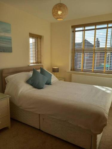 um quarto com uma cama grande e 2 almofadas azuis em Spacious 2 double bed apartment - Free Parking - Central Beeston location em Nottingham