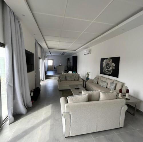 a living room with couches and a table and a couch at Al Saleh Chalet in Al Ashkharah