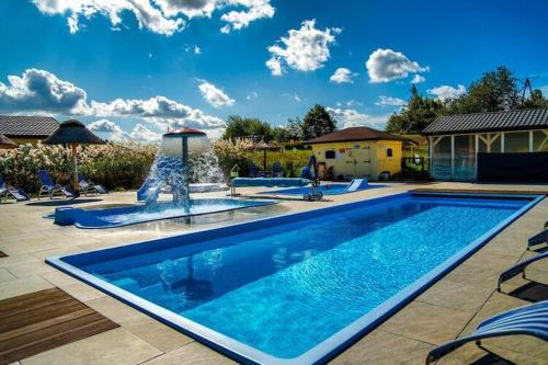 a large swimming pool with a fountain in a yard at Holiday resort with Pool Whirlpool Sauna Ustronie Morskie in Ustronie Morskie