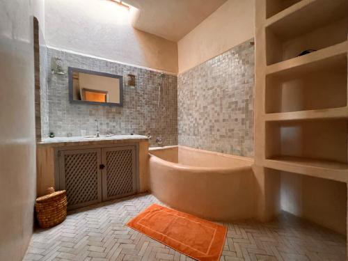 a bathroom with a tub and a sink at Dar Les Dattiers in Taroudant
