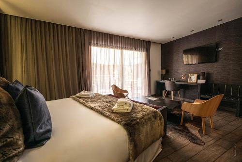 um quarto de hotel com uma cama e uma secretária em Hôtel Le Parc - La Table de Franck Putelat em Carcassonne