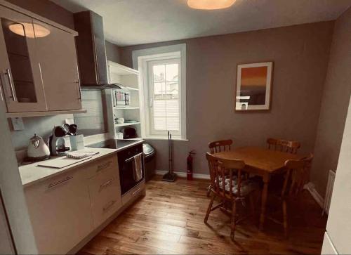 a kitchen with a table and a dining room at Beautiful House In Town in Killarney