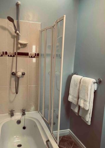 a bathroom with a shower and a bath tub at Beautiful House In Town in Killarney