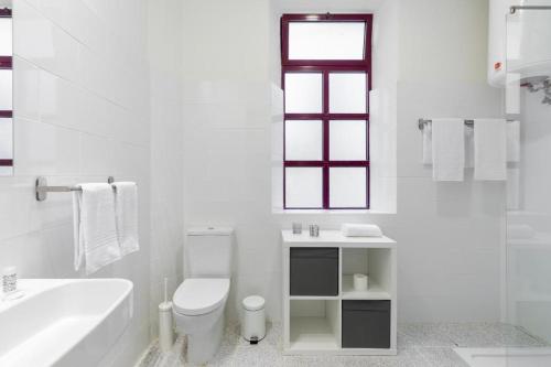 a white bathroom with a toilet and a sink at Boho House Terrace in Porto