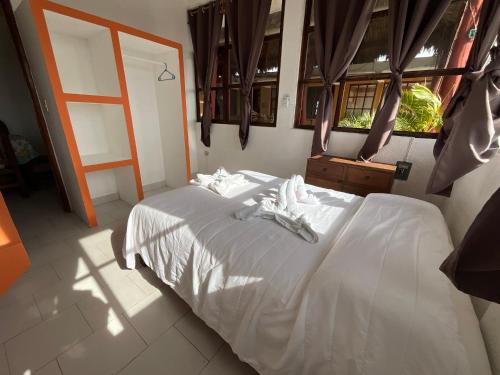 a bedroom with a white bed with towels on it at Hotel Bello Caribe in Cozumel