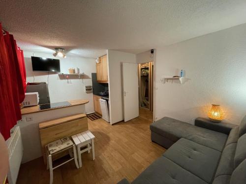 een woonkamer met een bank en een keuken bij Appartement Plagnes Villages in La Plagne Tarentaise