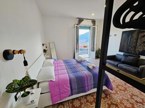 a bedroom with a bed and a couch and a window at The view in La Spezia