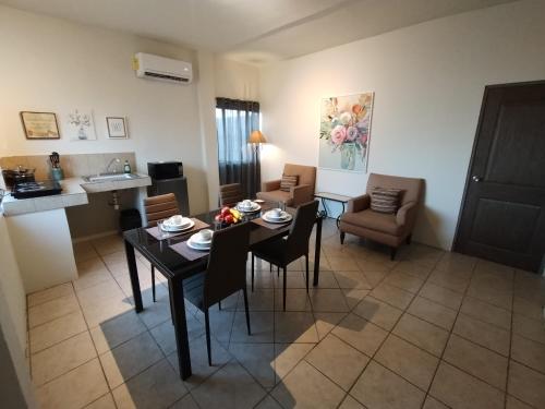 a living room with a table and chairs and a kitchen at Tres Migueles, Departamento Alaain, cerca de la marina, zona turistica y playa in Cabo San Lucas