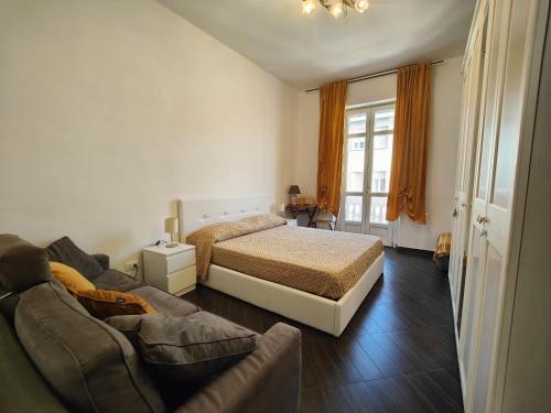 a bedroom with a bed and a couch at Tania House, Metro Italia 61 in Turin