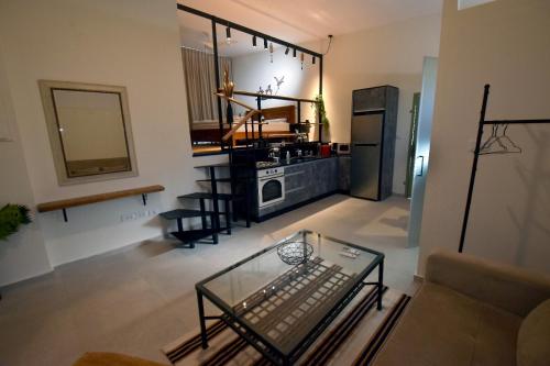 uma sala de estar com uma mesa de vidro e uma cozinha em Desert view studio em Beʼer Ora