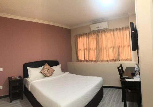 Habitación de hotel con cama y ventana en Express Hotel, en Nilai