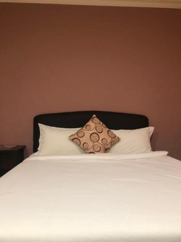 Una cama blanca con una almohada encima. en Express Hotel, en Nilai