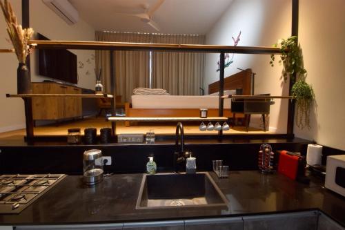 a kitchen with a sink and a living room at Desert view studio in Beʼer Ora