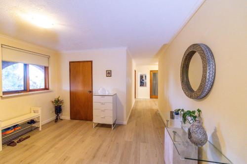 a living room with a mirror and a dresser at Cooma Guest House in Cooma